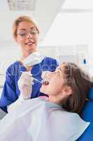 Smiling pediatric dentist examining her young patient