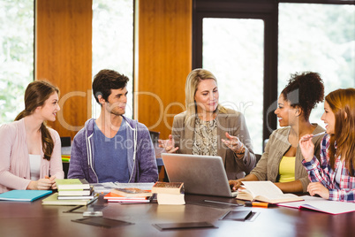 Smiling female with students and teacher in library