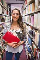 Pretty student picking out a book in library