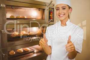 Baker smiling at camera beside oven