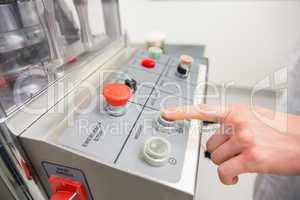 Pharmacist pressing button on machine