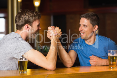 Happy friend arm wrestling each other