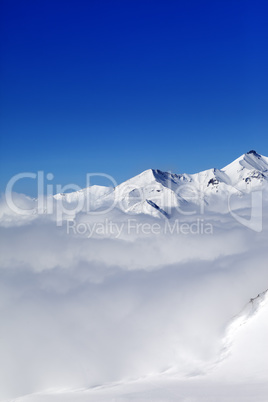 Mountains in clouds at nice winter day