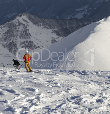 Freeriders on off-piste slope in sun nice evening