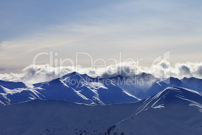 Evening winter mountains and sunlight clouds