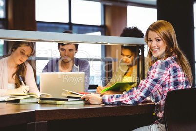 Smiling student sitting at desk looking at camera