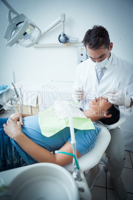 Male dentist examining womans teeth