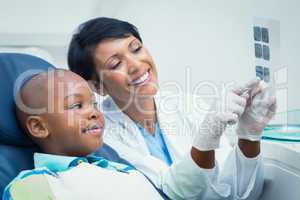 Female dentist showing boy his mouth x-ray