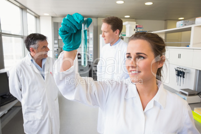 Young scientist holding up test tube