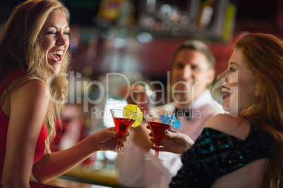 Pretty girls toasting with cocktails