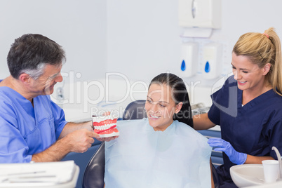 Dentist and nurse explaining to their patient how use toothbrush