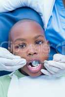 Boy having his teeth examined by dentist