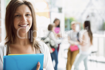 Pretty student smiling and holding notepads