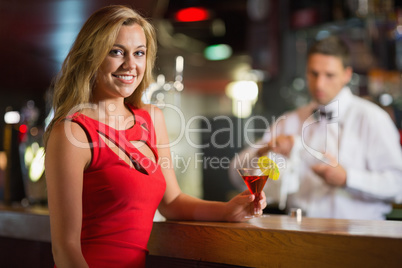 Pretty blonde smiling at camera with cocktail