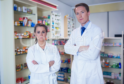 Pharmacist and his trainee standing with arms crossed