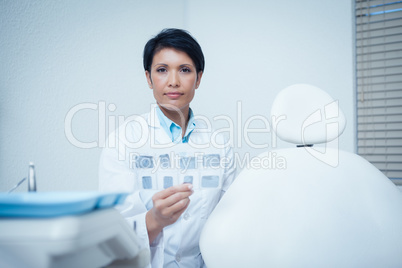 Portrait of female dentist holding x-ray