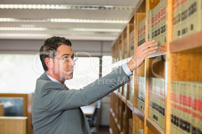 Lawyer picking book in the law library