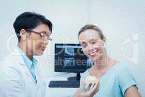 Dentist showing woman prosthesis teeth