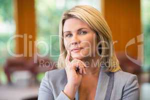 Blonde businesswoman thinking looking at camera