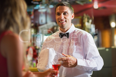 Handsome barman chatting to customer