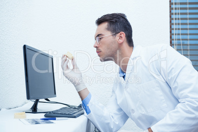 Dentist holding mouth model by computer
