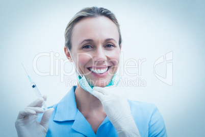 Smiling female dentist holding injection