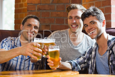 Happy friends toasting with pints of beer