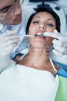 Male dentist examining womans teeth