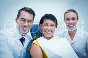 Portrait of smiling dentist and assistant with female patient