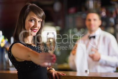 Pretty brunette smiling at camera with champagne