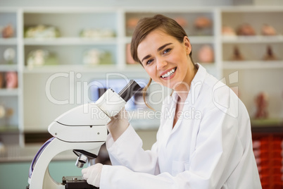 Young scientist working with microscope