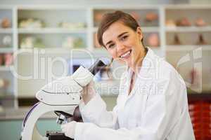 Young scientist working with microscope