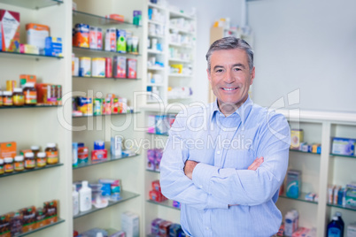 Portrait of a smiling pharmacist standing with arms crossed