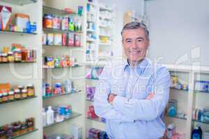 Portrait of a smiling pharmacist standing with arms crossed