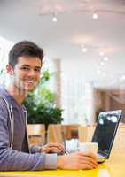 Young student using his laptop in cafe