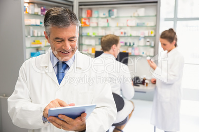 Senior pharmacist using tablet pc