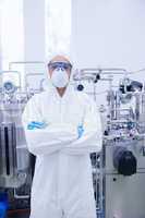 Scientist in protective suit standing with arms crossed