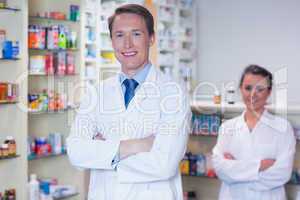 Pharmacist with his trainee standing with arms crossed
