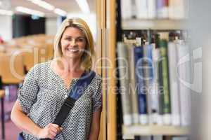 Mature student studying in the library with tablet