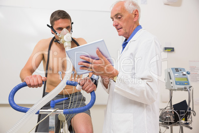 Doctor showing tablet pc to man doing fitness test