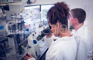 Biochemistry students using large microscope and computer