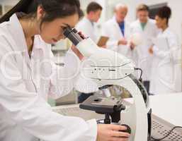 Young medical student working with microscope