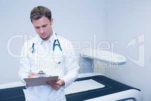 Doctor noting something on his clipboard