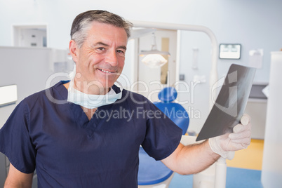 Smiling dentist examining a x-ray