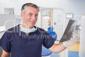 Smiling dentist examining a x-ray