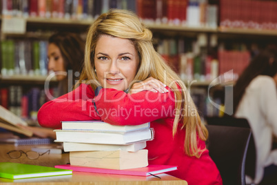 Smiling mature student leaning on a stack of books