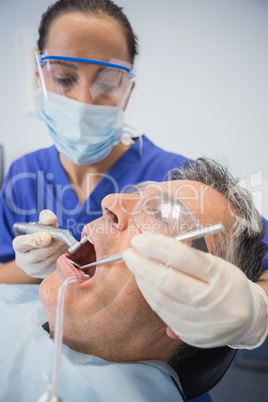 Dentist examining a patient with tools