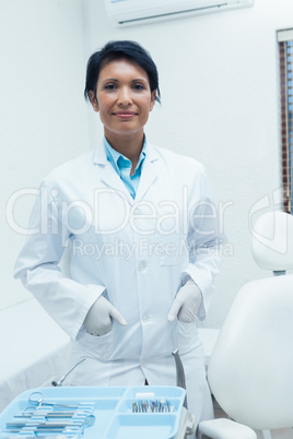 Smiling female dentist with hands in pockets