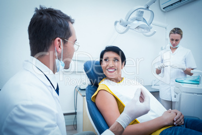 Dentist and assistant with smiling female patient