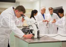 Young medical student working with microscope